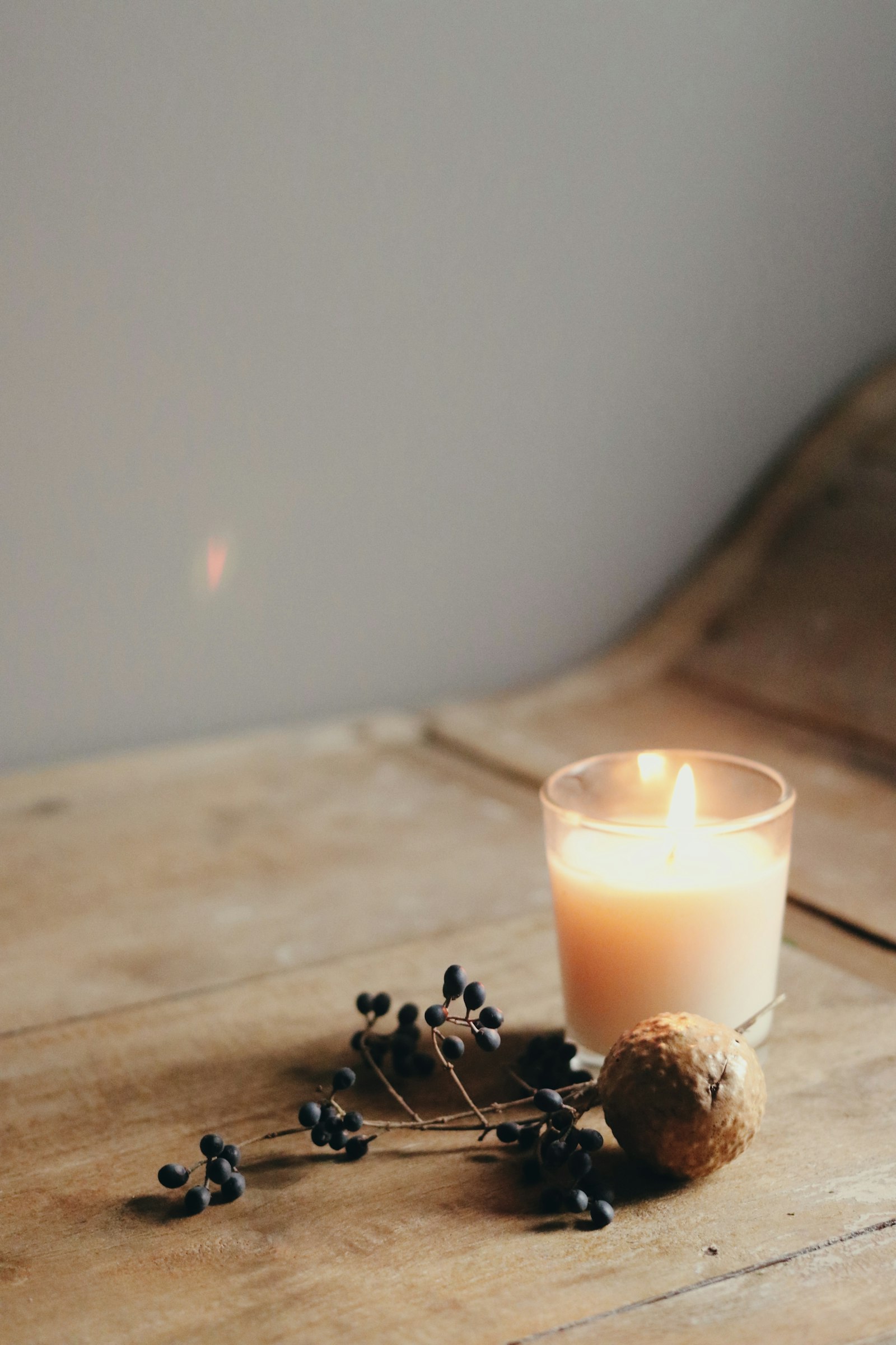 A soy candle burning in a clear glass vessel