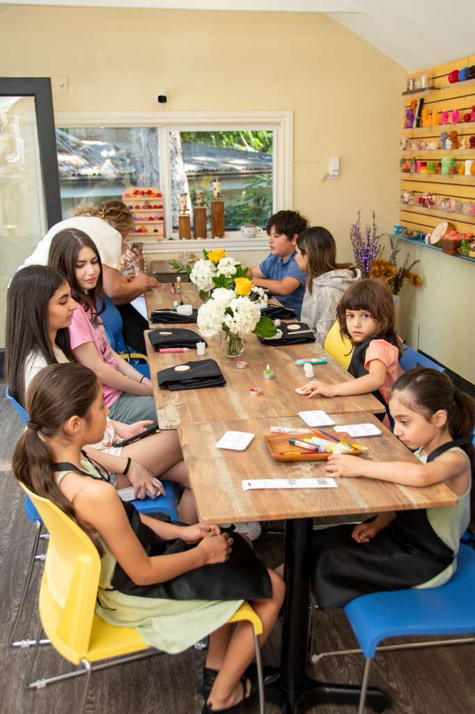 Children and teens seated around the workshop table