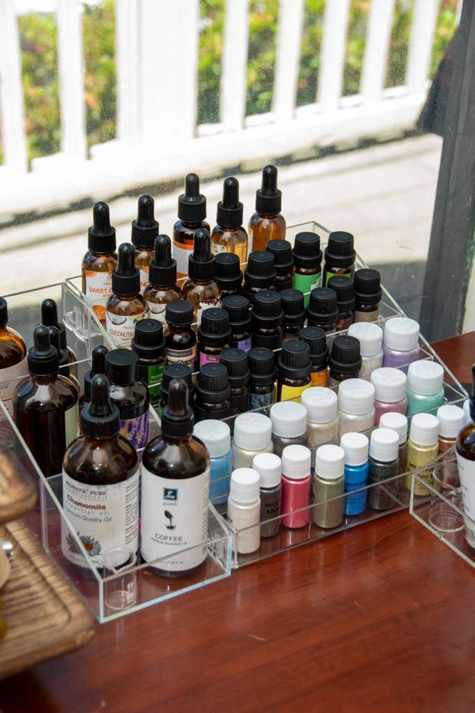 Tray of fragrance oils and pigments by a window